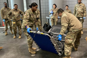 New York Army National Guard Soldiers with the 133rd Composite Supply Company assemble a cot at the Jacob K. Javits Convention Center in New York City.