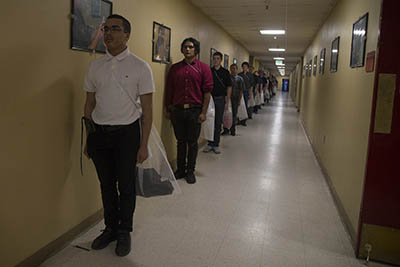 New recruits with Bravo Company, 1st Recruit training Battalion, stand in line to receive their initial haircuts at Marine Corps Recruit Depot