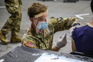 Army Sgt. Trevor McNally, a combat medic assigned to the 626th Brigade Support Battalion, administers a COVID-19 vaccine at the Orlando Community Vaccination Center in Orlando, FL, in late March. DoD is helping the Federal Emergency Management Agency vaccinate as many Americans as possible against COVID-19. Army photo by Spc Zachery Blevins/101st Airborne Division Public Affair)